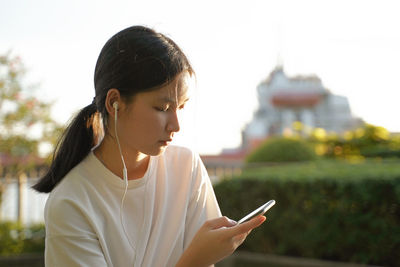 Teenage girl listening to music while sitting outdoors