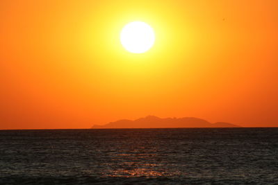 Scenic view of sea against orange sky