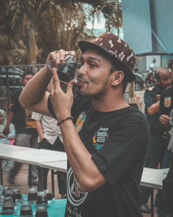 Young man drinking black coffee in cup and saucer