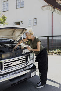 Woman repairing car