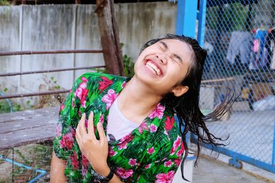 Beautiful young woman smiling while standing against water