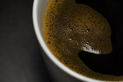 Close-up of coffee cup against black background