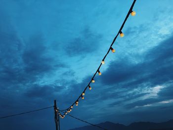 Low angle view of electricity pylon against blue sky