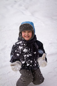 Portrait of smiling boy playing in snow