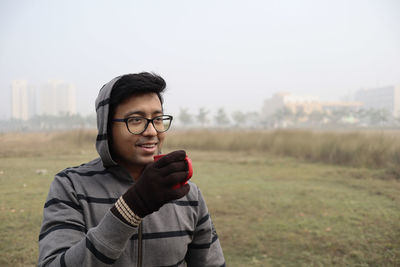 Portrait of young man standing on field