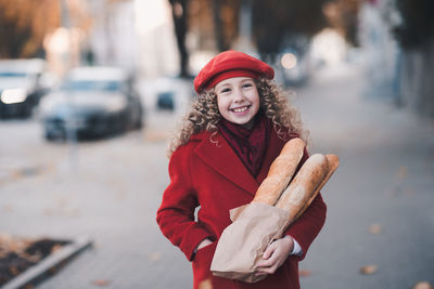 Portrait of girl holding bread outdoors