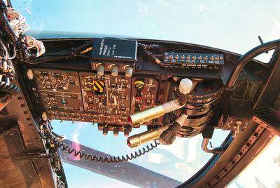 Low angle view of airplane cockpit flying against sky