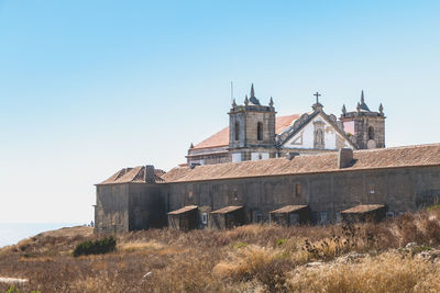 Low angle view of old building against clear blue sky