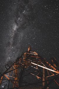 Low angle view of communications tower against star field in sky