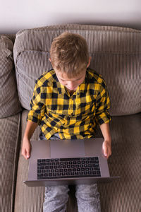 Man using mobile phone while sitting on sofa