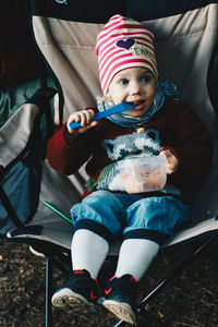 High angle view of cute girl sitting on camping chair