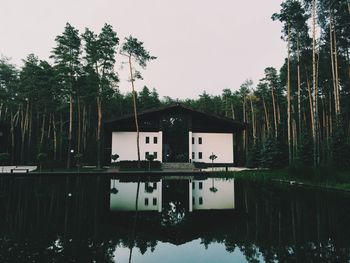 Reflection of built structure in water against clear sky