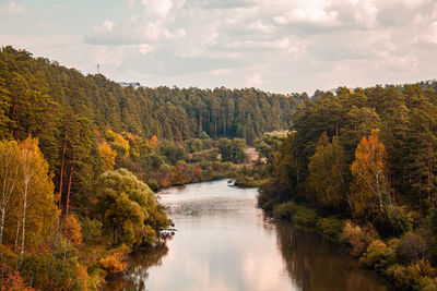 Scenic view of river amidst trees against sky during autumn