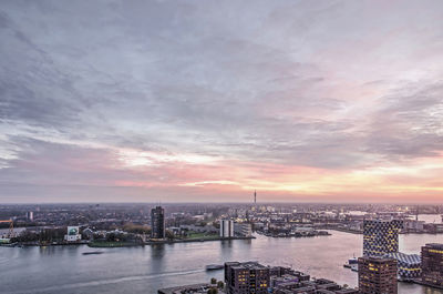 Aerial view of river and cityscape against cloudy sky during sunset