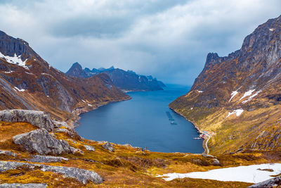 Scenic view of sea amidst mountains against cloudy sky