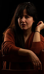 Portrait of beautiful young woman sitting on chair