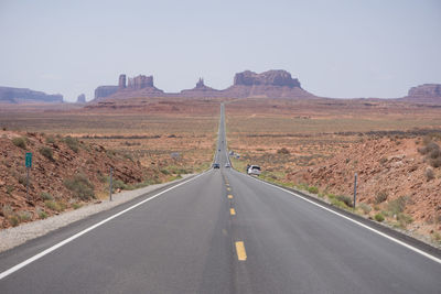 Road leading towards mountains against sky