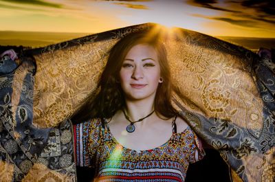 Portrait of beautiful young woman at sunset