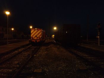 Train on railroad tracks in city at night