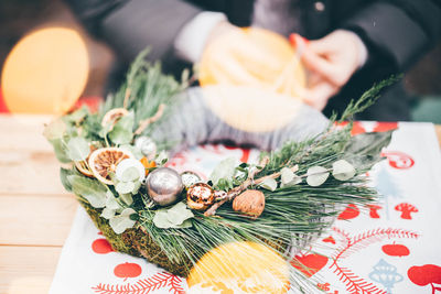 Low section of woman with christmas decorations on table