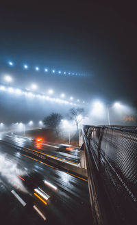 Light trails on street against sky at night