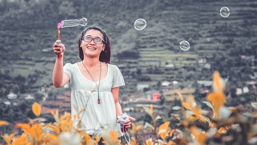 Portrait of smiling young woman standing outdoors