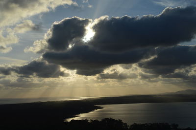 Scenic view of sea against cloudy sky at sunset