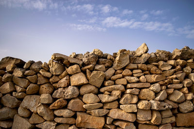 Stack of rocks on field against sky