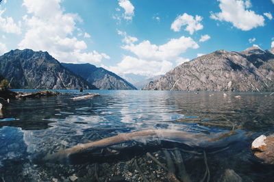 Scenic view of lake sary-chelek against cloudy sky