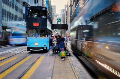 Blurred motion of train on street in city