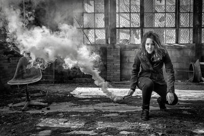 Portrait of young woman with distress flare in abandoned room