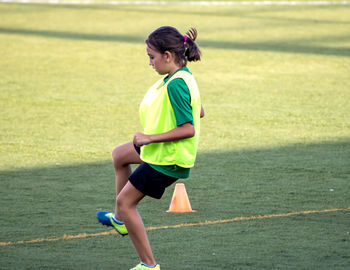 Side view of boy running on grass