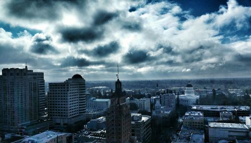 Cityscape against cloudy sky