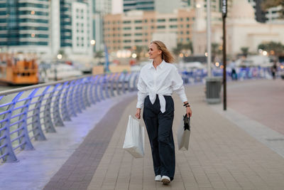 A confident, attractive woman holding shopping bags. black friday, shopping