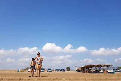 Panoramic view of people on beach against sky