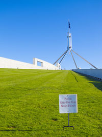 Information sign on field against clear sky