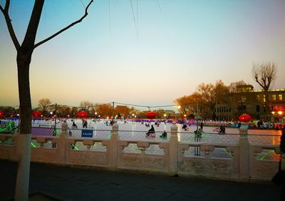 People in swimming pool against sky at dusk