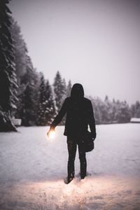 Full length of woman walking on snow covered landscape