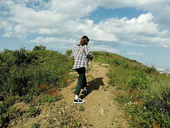 Girl going forward on the mountain path during summer day