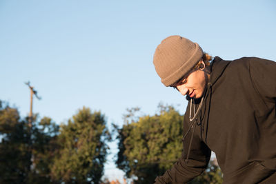 Portrait of young skateboarder enjoying sun outdoors