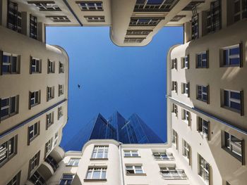 Low angle view of tall buildings against blue sky