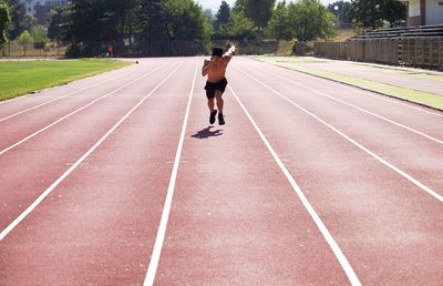 Shirtless man running on track