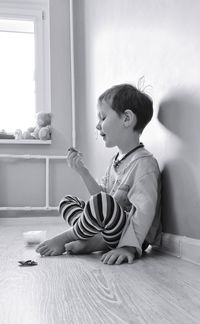 Full length of boy sitting on floor at home