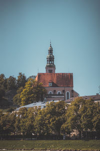 Building by trees against clear sky