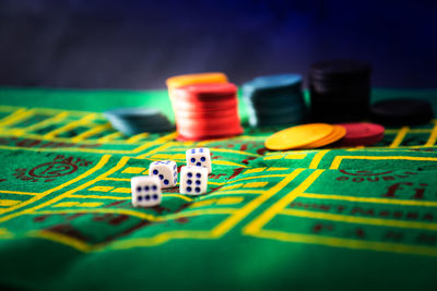 Close-up of gambling chips and dices on table at casino