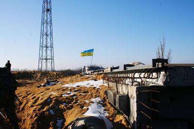 Electricity pylon on land against clear sky during winter
