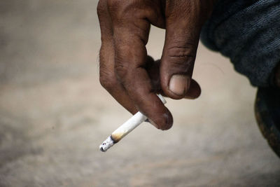 Midsection of man smoking cigarette