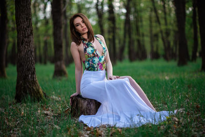 Woman with arms raised on field in forest