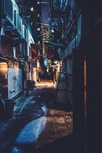 Illuminated alley amidst houses