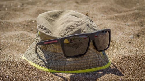 Close-up of sunglasses on sand
